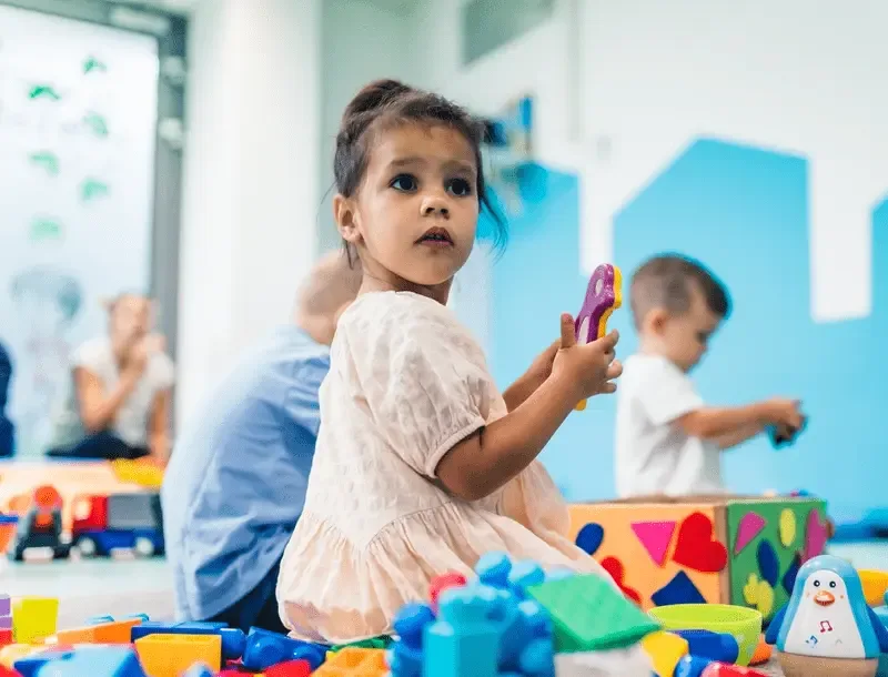 A child exploring toys in a sensory-rich play setting
