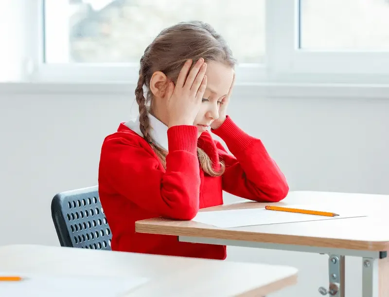 A child finding a classroom activity difficult
