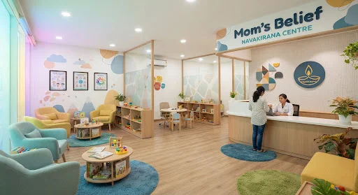 Bright welcoming reception area and consultation space at Mom's Belief Navakirana Centre featuring comfortable parent coaching zones and playful neurodiversity-friendly design elements.